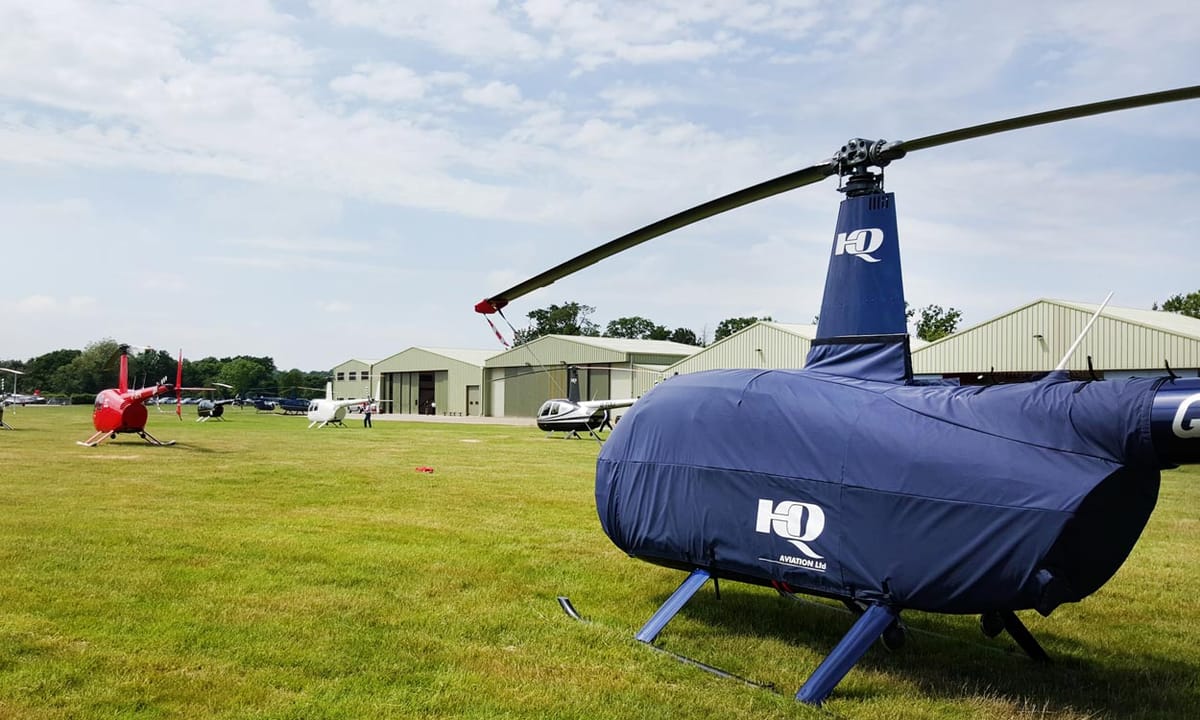 HQ-branded navy Air Covers cabin cover on a Robinson R44 at Denham