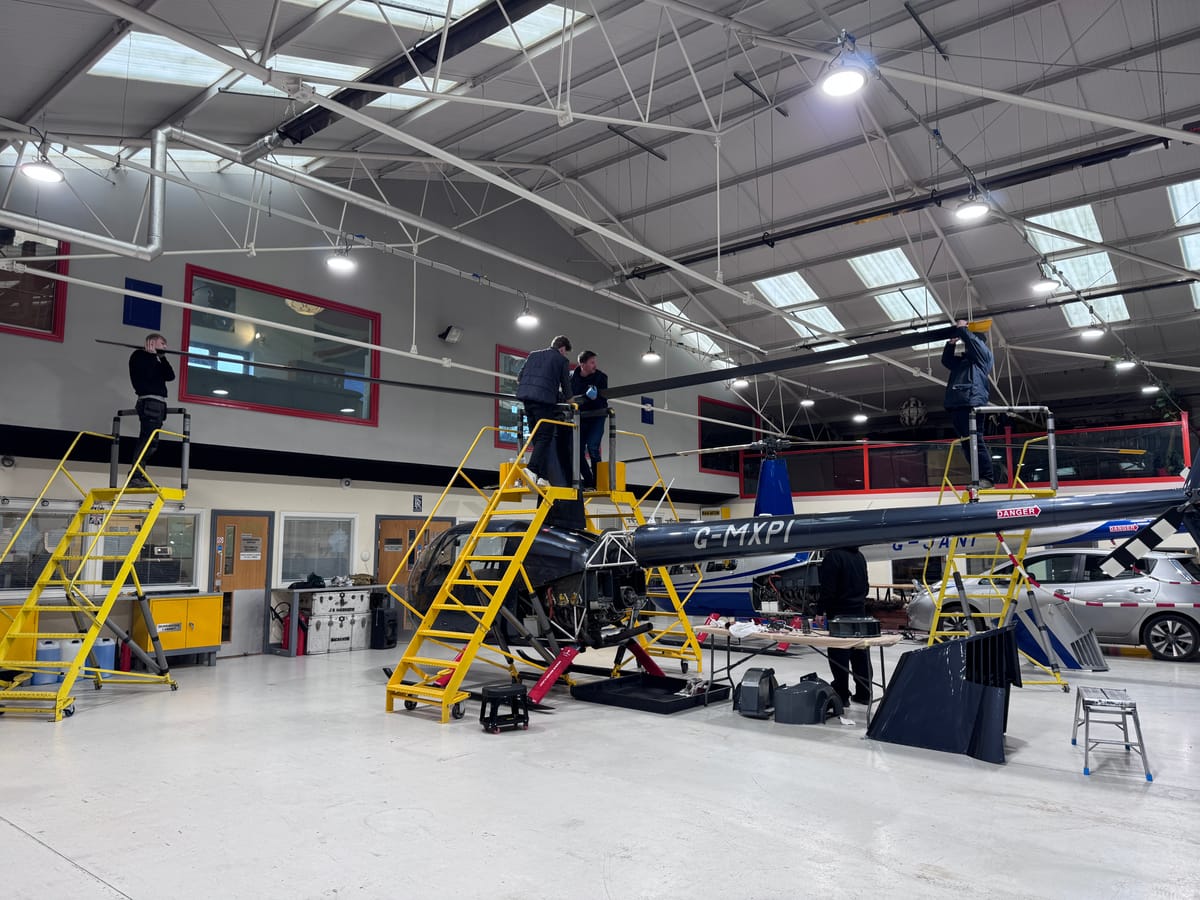 Engineers working on Robinson helicopters in the HQ Aviation maintenance hangar at Denham